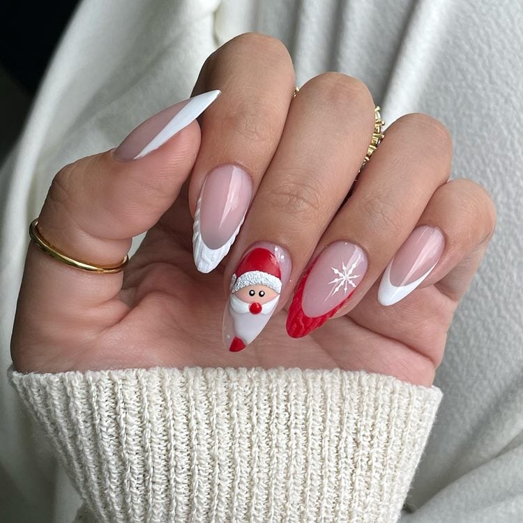 Mão com unhas decoradas para Natal, cores vermelho, branco e nude, desenho de papai noel, floco de neve e francesinha texturizada