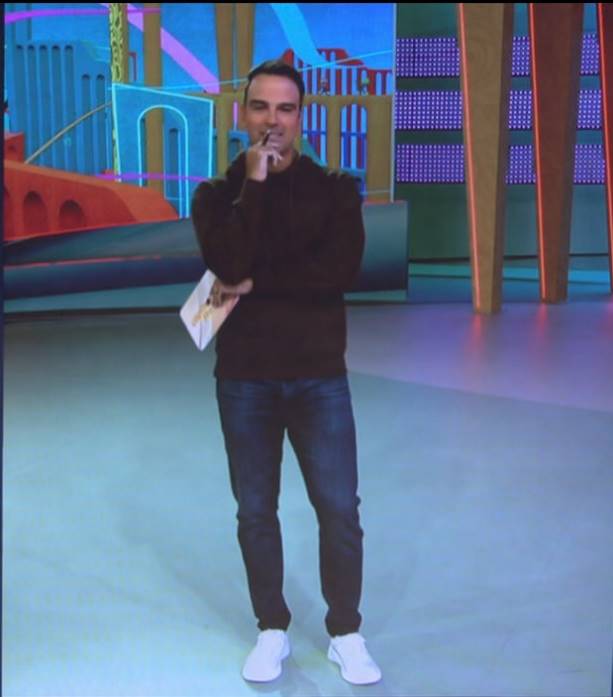 Tadeu Schmidt. apresentador do BBB 24, com blusa preta,,calça jeans e tênis branco, momento antes da sexta eliminação