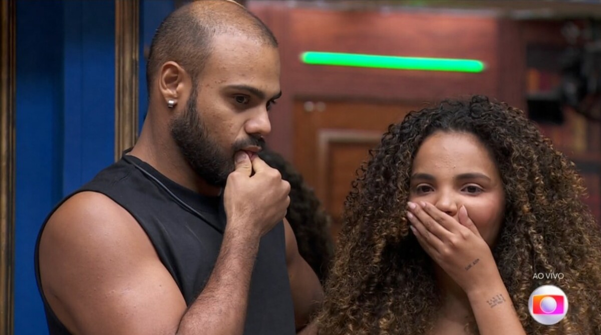 Foto de Marcus Vinicius e Giovanna Pitel após a indicação ao Paredão feita pelo contragolpe. Os participantes do BBB 24 estão com a mão na boca e olhar de choque