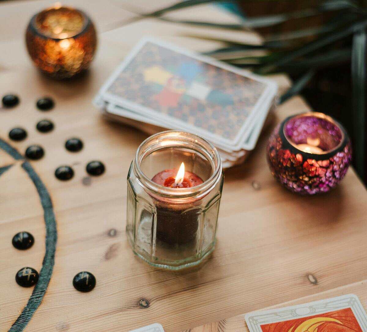 Mesa esotérica com cartas de tarot e velas
