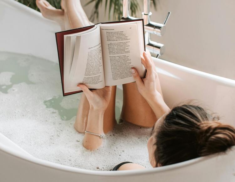 Mulher lendo livro na banheira