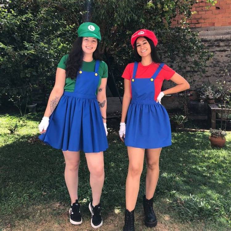 Mulheres de pele clara e cabelo escuro fantasiadas de Mario e Luigi.
