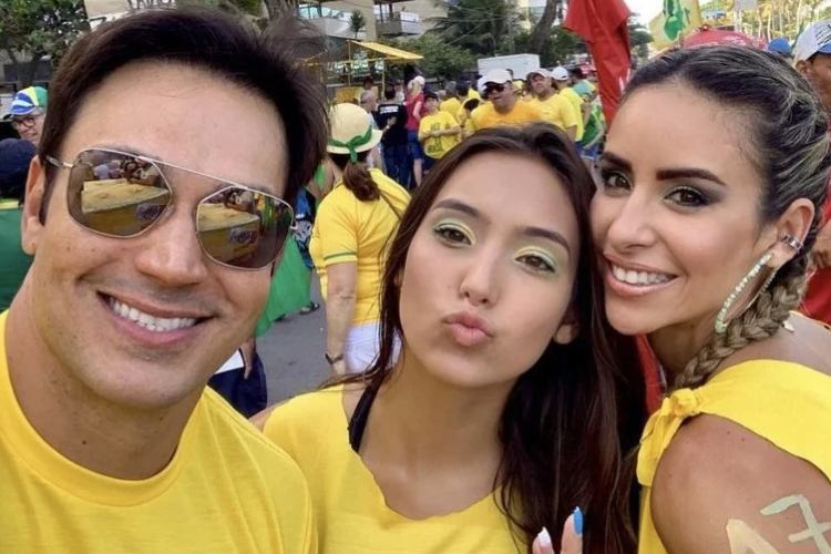 Imagem mostra a influenciadora digital Vanessa Lopes ao lado de seus pais. Os três vestem camisetas amarelas em uma passeata a favor de Bolsonaro.