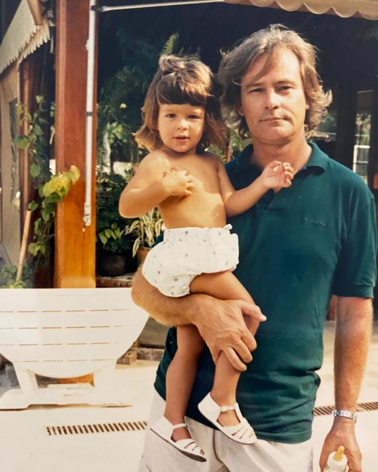 Antes e depois cabelo participante do BBB 24: modelo quando criança ao lado do pai em foto em casa com plantas e banco
