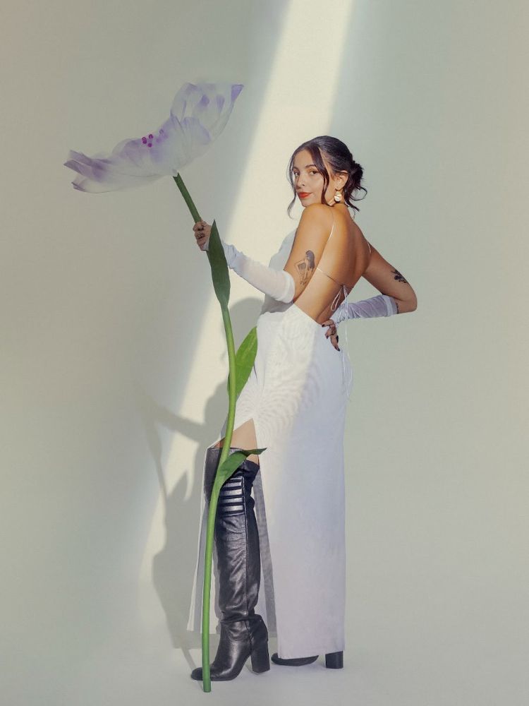 mulher usando botas pretas e vestido branco da Lela Brandão Co., marca de moda feminina confortável