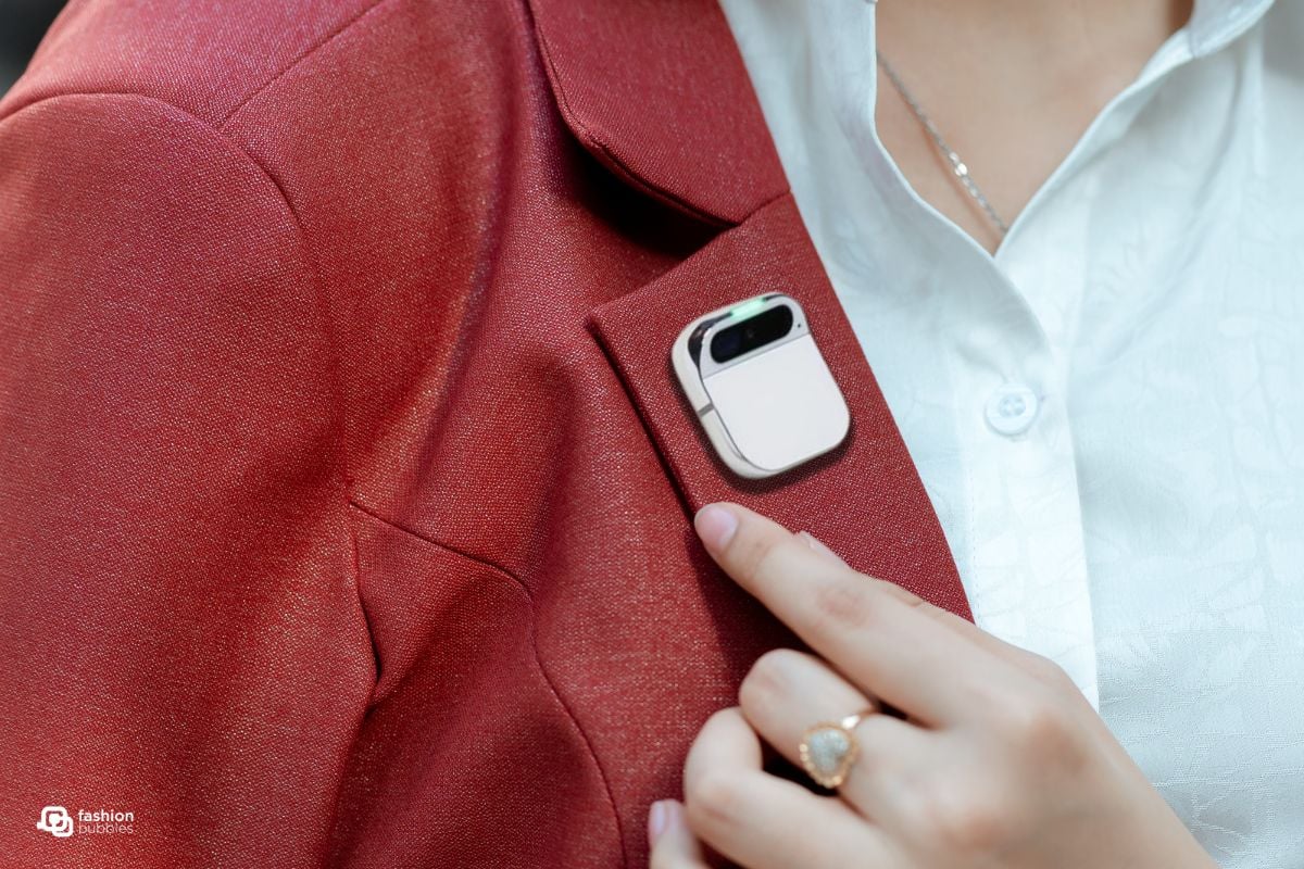 Montagem com foto de pessoa usando blazer vermelho com o AI Pin, broche com inteligência artificial