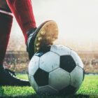 foto de pé de jogador de futebol com chuteira pisando em cima de bola antes de começar a partida ao vivo no estádio