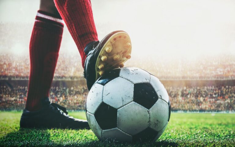 foto de pé de jogador de futebol com chuteira pisando em cima de bola antes de começar a partida ao vivo no estádio