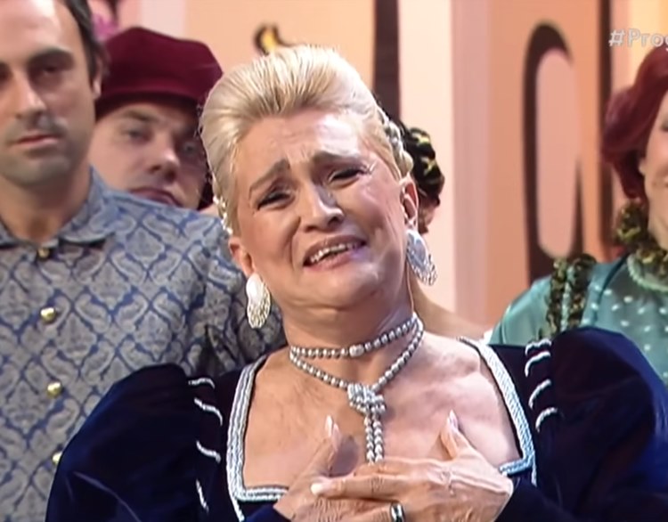 A rainha da televisão usando roupa inspirado em Julietta da peça teatral na qual ela interpreta ao lado de Tiririca e Ratinho, que não aparecem na foto. No fundo, há outros personagens da cena