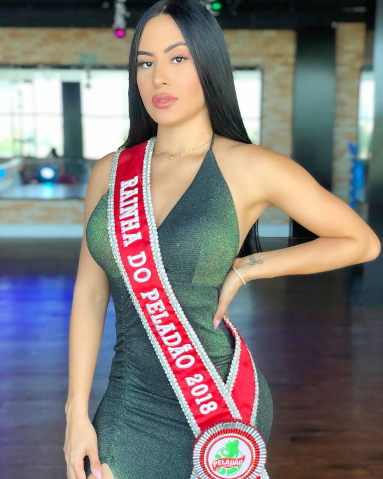 Isabelle do BBB 24 com faixa de rainha do peladão 2018 usando vestido verde com a mão na cintura