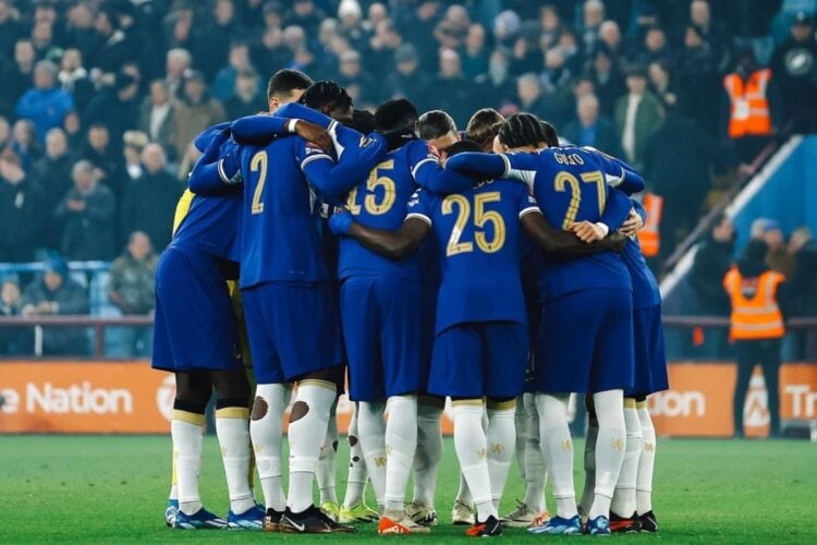 Jogadores do Chelsea com primeiro uniforme se abraçando em campo
