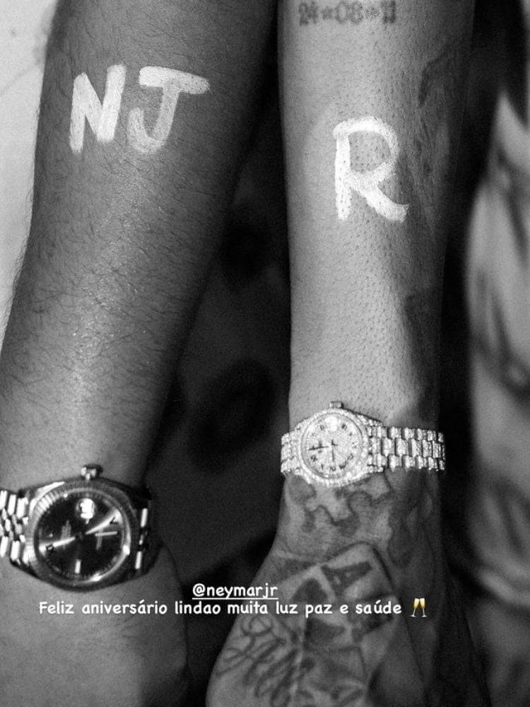 Braço de Ryan SP e Neymar com "NJ" e "R" desenhos com tinta e feliz aiversário para Neymar