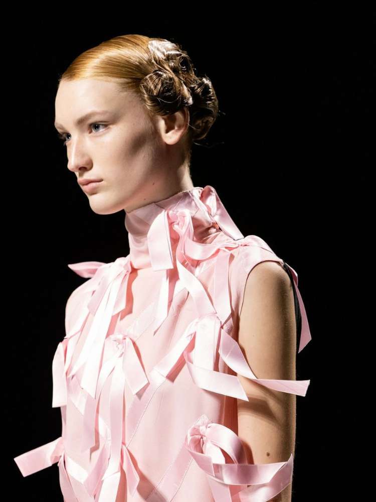 Modelo com laços na passarela da Milão Fashion Week