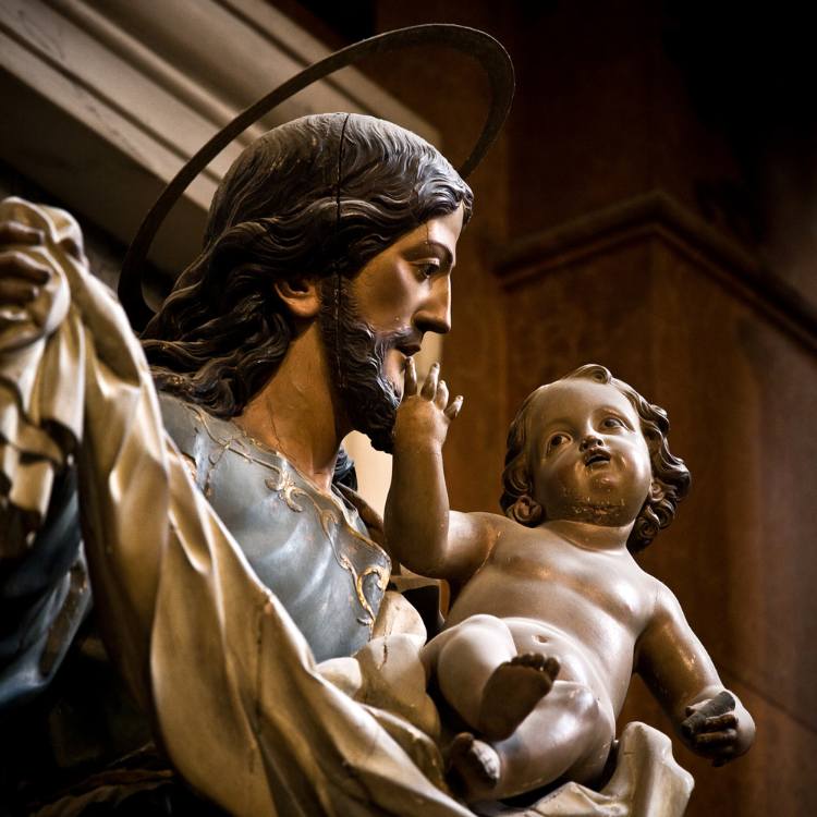 Imagem de gesso dos santos São José com o menino Jesus no colo.

