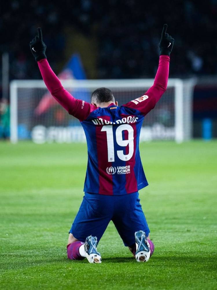 Vitor Roque em campo de joelhos e de costas usando a camisa 19 do Barcelona com seu nome