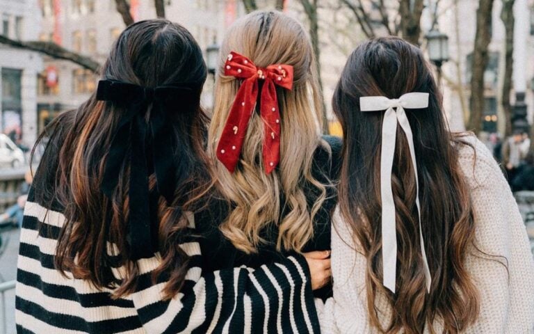foto de três mulheres de costas usando penteados com laços no cabelo