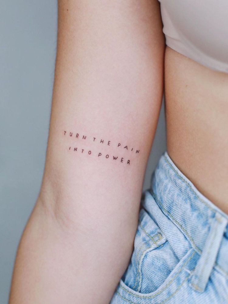 foto de braço de mulher com a frase Turn the pain into power tatuada