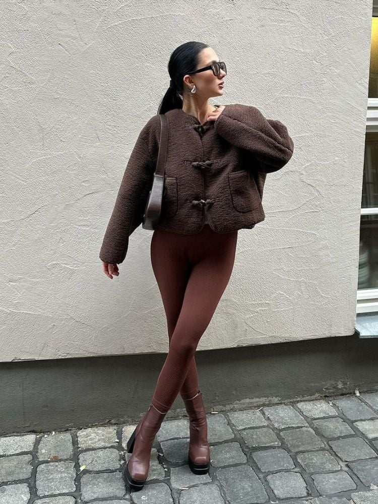 mulher usando casaco, legging e bota em look marrom