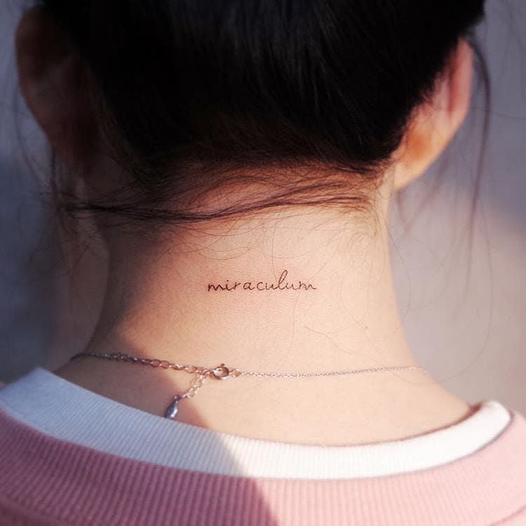 foto de mulher com tatuagem de palavra em latim no pescoço