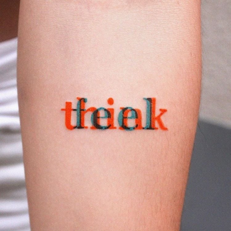 tatuagem no braço de palavras coloridas