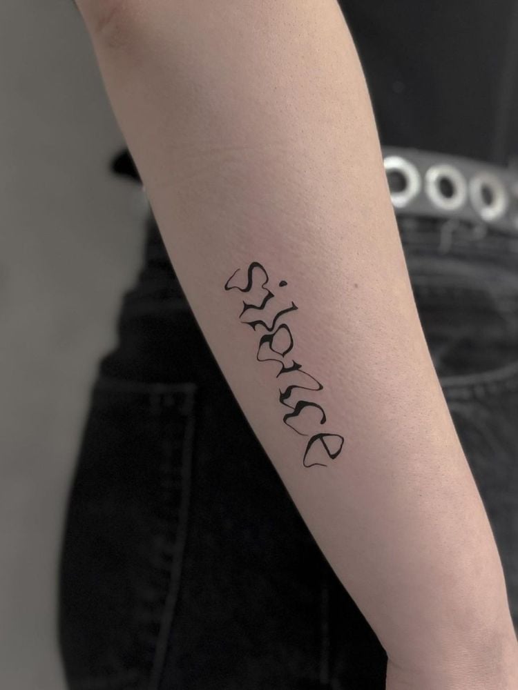 foto de mulher com tatuagem de palavra no braço