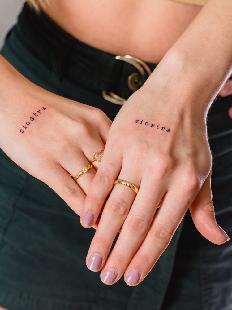 foto de duas mãos de mulher com a mesma tatuagem escrito siostra, que significa irmã em polonês