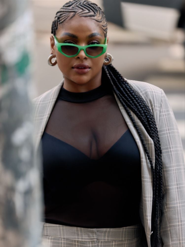 mulher usando blusa preta com transparência e blazer xadrez da nova coleção da marca Ashua Curve & Plus Size