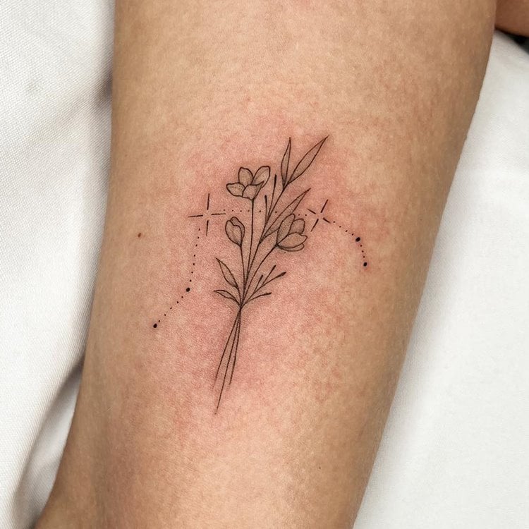 Tattoo de constelação do signo de Áries, cores: preto. Com ramo de flor no meio