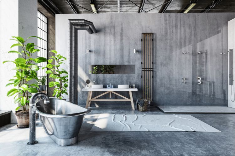 Banheiro com decoração industrial, com banheira de metal, janelas grandes, tubulações à vista e parede de cimento queimado
