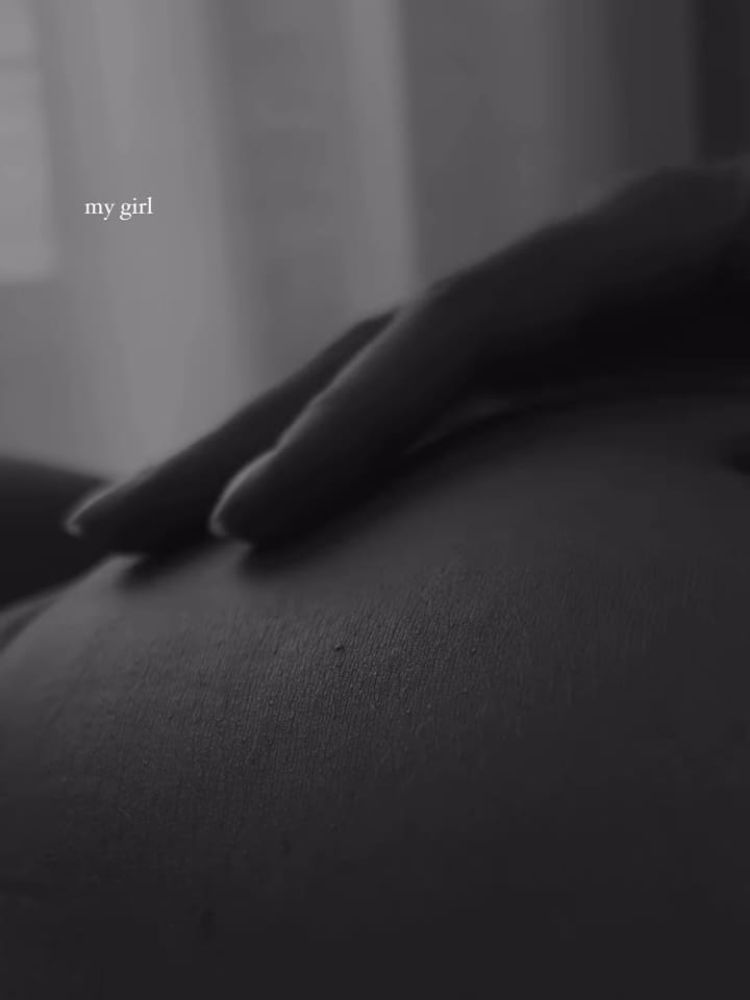 Print de vídeo em preto e branco de Kimberlly passando a mão na barriga e escrito "my girl" em branco no canto superior esquerdo