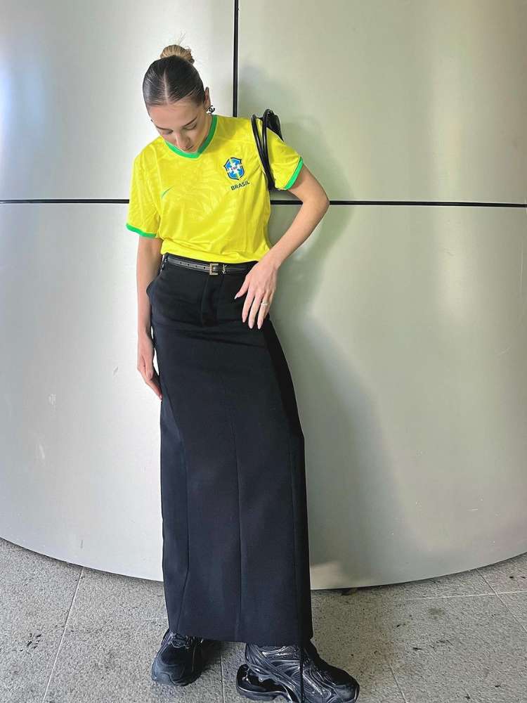 Malu Borges usando camisa amarela do Brasil com saia longa preta