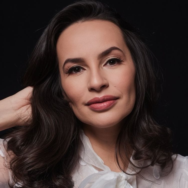 Foto profissional de um ensaio com Denise Pitta usando maquiagem suave e uma blusa branca.
