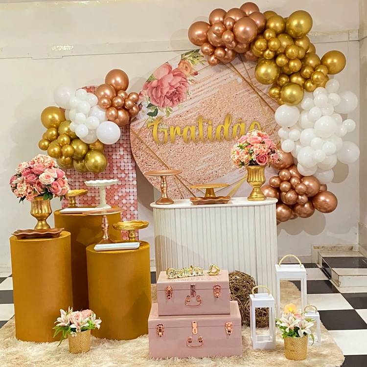Tons de dourado, rosa e branco, sem doces ou bolos, sobre tapete de pelo em ambiente interno.