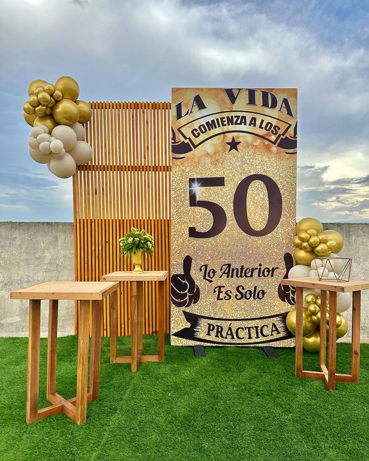 Aniversário de 50 anos ao ar livre simples com placa de 50 anos Grande balões dourado e mesas que faltam os doces
