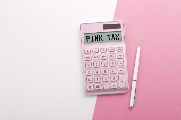 Calculadora rosa escrito Pink Tax ao lado de caneta e com fundo rosa claro e escuro