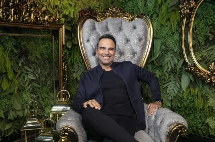 Tadeu Schmidt sentado na poltrona dentro do Confessionário