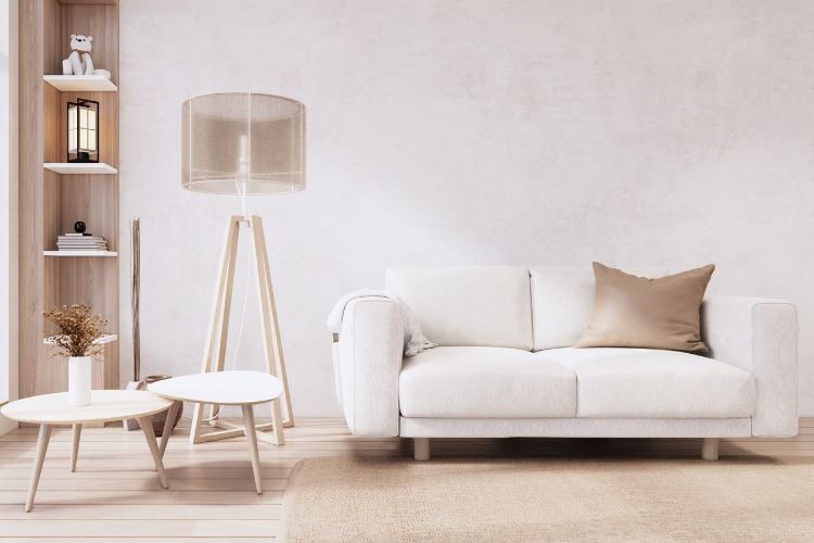 Sala com decoração minimalista: sofá branco, mesa de centro branca, abajur alto bege
