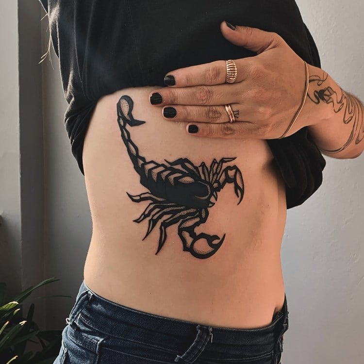 Tatuagem preta de signo escorpião nas costelas