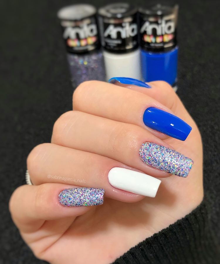 Unhas decoradas em tons de azul com Com glitter e filha única branca
