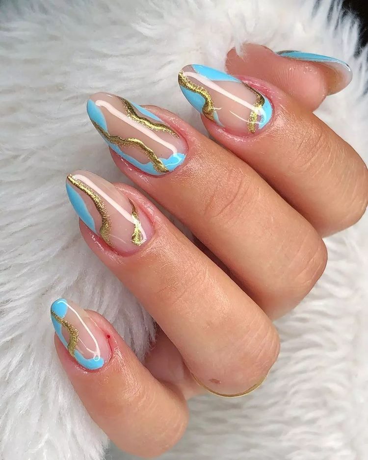 unha bege com decoração de ondas azul-claro e dourado
