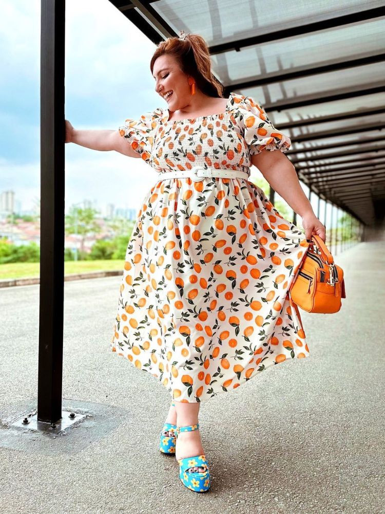 Influencer Ju Romano usando vestido midi rodado branco com estampa de limões sicilianos e sandália azul com estampa de flores