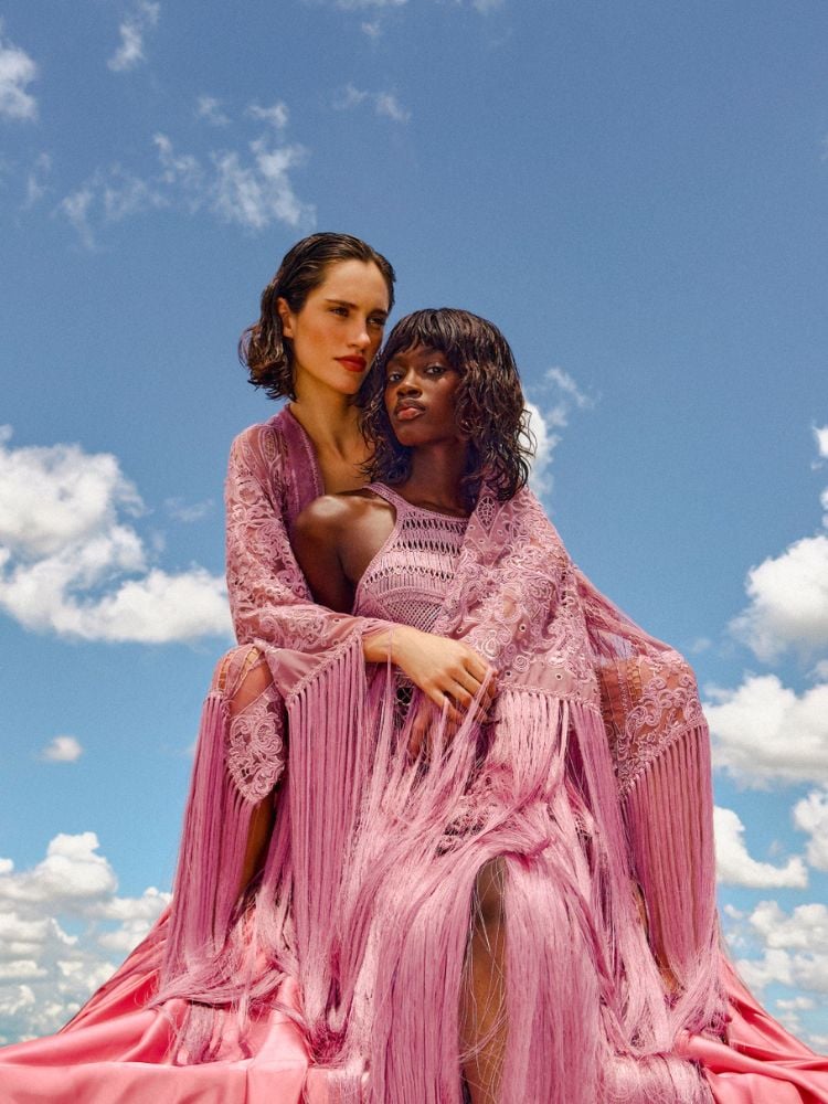 foto da campanha de PatBo gravada com iPhone mostra duas mulheres usando vestidos longos cor-de-rosa com franjas