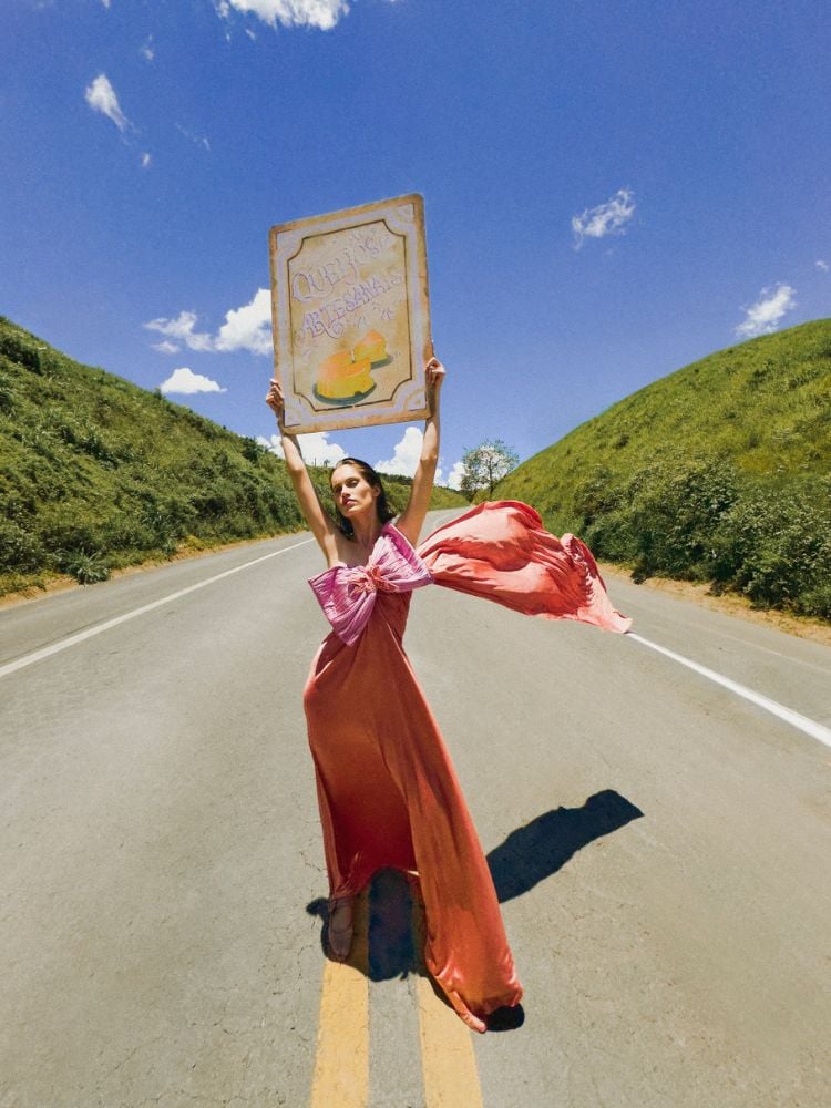 foto da campanha de PatBo gravada com iPhone mostra mulher usando vestido com laço rosa em estrada