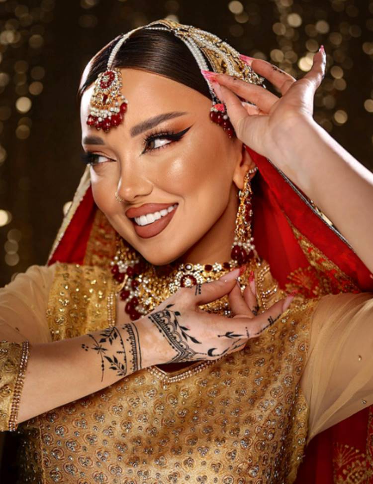 Mulher com roupa indiana vermelha e dourada e make nude