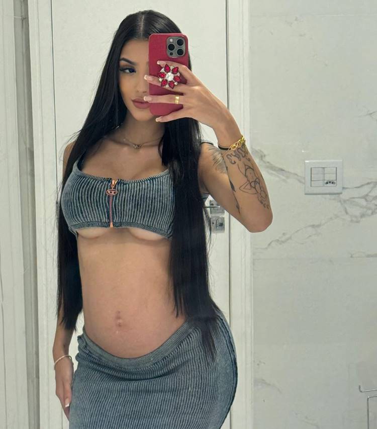 Influenciadora Bia Miranda grávida em 2024 usando top e saia longa em foto no espelho