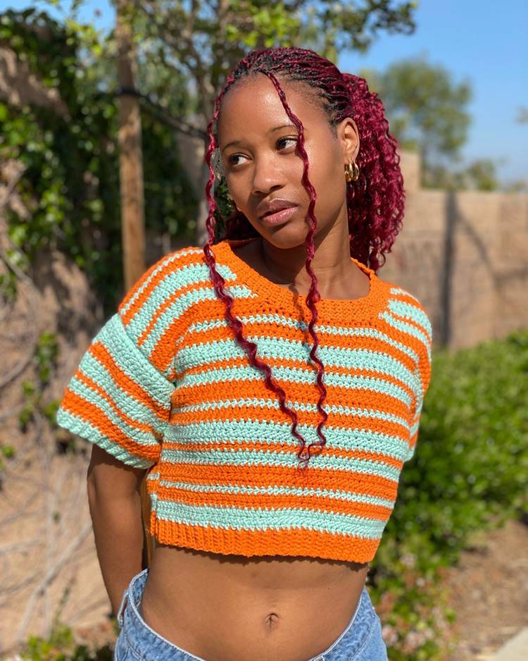 Menina usando roupa de crochet colorido laranja e azul