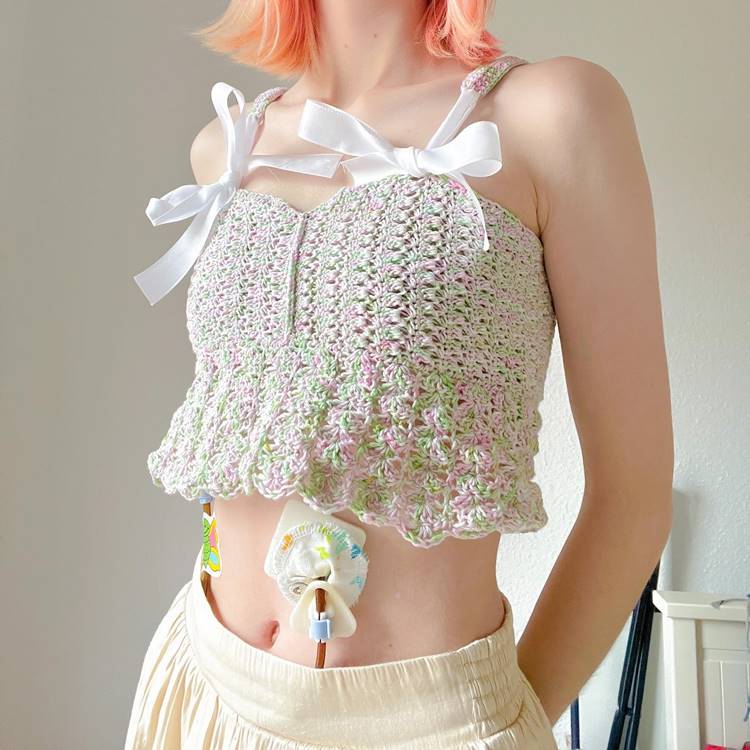 Menina usando cropped de crochê colorido com laços de fita
