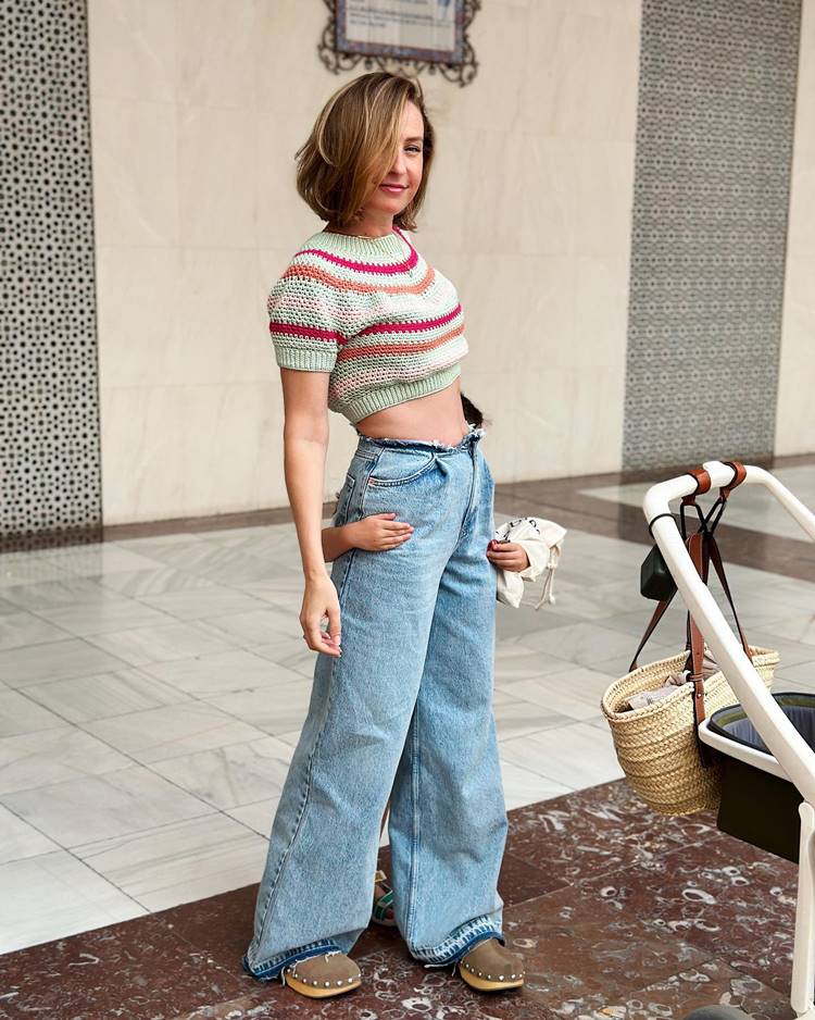 Mulher usando cropped de crochê colorido e calça jeans