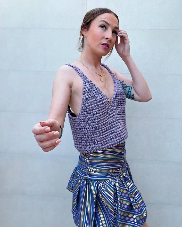 Mulher usando cropped de crochê azul com saia mini metalizada colorida