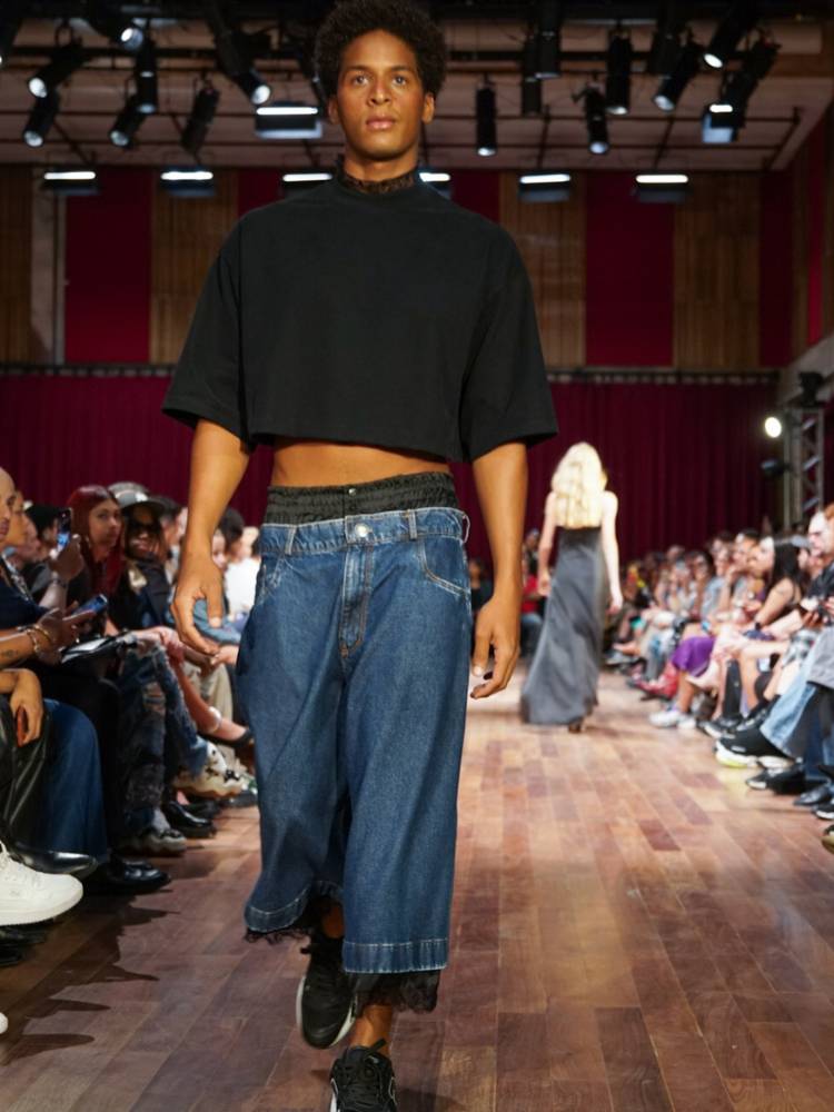Homem de pele negra de cropped preto e calça jeans